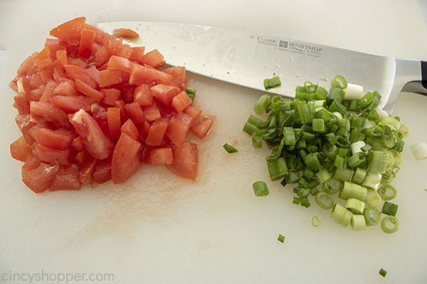 Diced tomato and green onion on cutting board