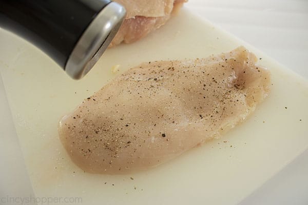 Adding salt and pepper to chicken breast