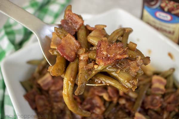 Spoon with green beans bacon and sauce