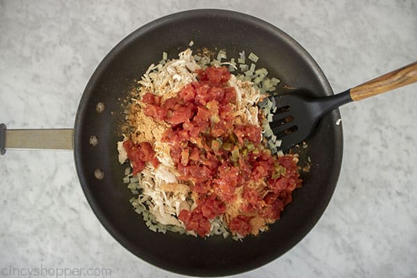 Chicken, tomatoes, chiles, and the taco seasoning added to onions