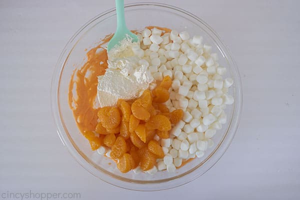 Marshmallows, oranges and cool whip added to bowl
