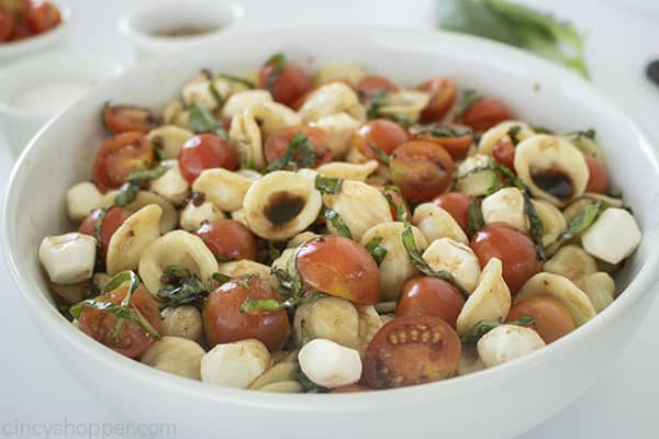 Caprese Pasta Salad with dressing in a bowl