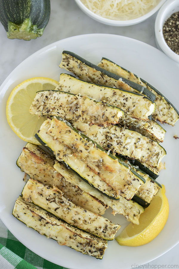 Oven Zucchini with Parmesan on a plate with lemons