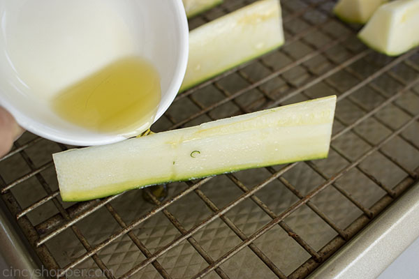 Drizzling oil on zucchini 