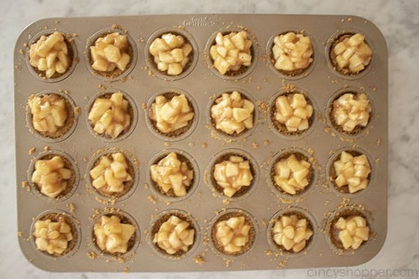 Apple filling added to crust bites in pan