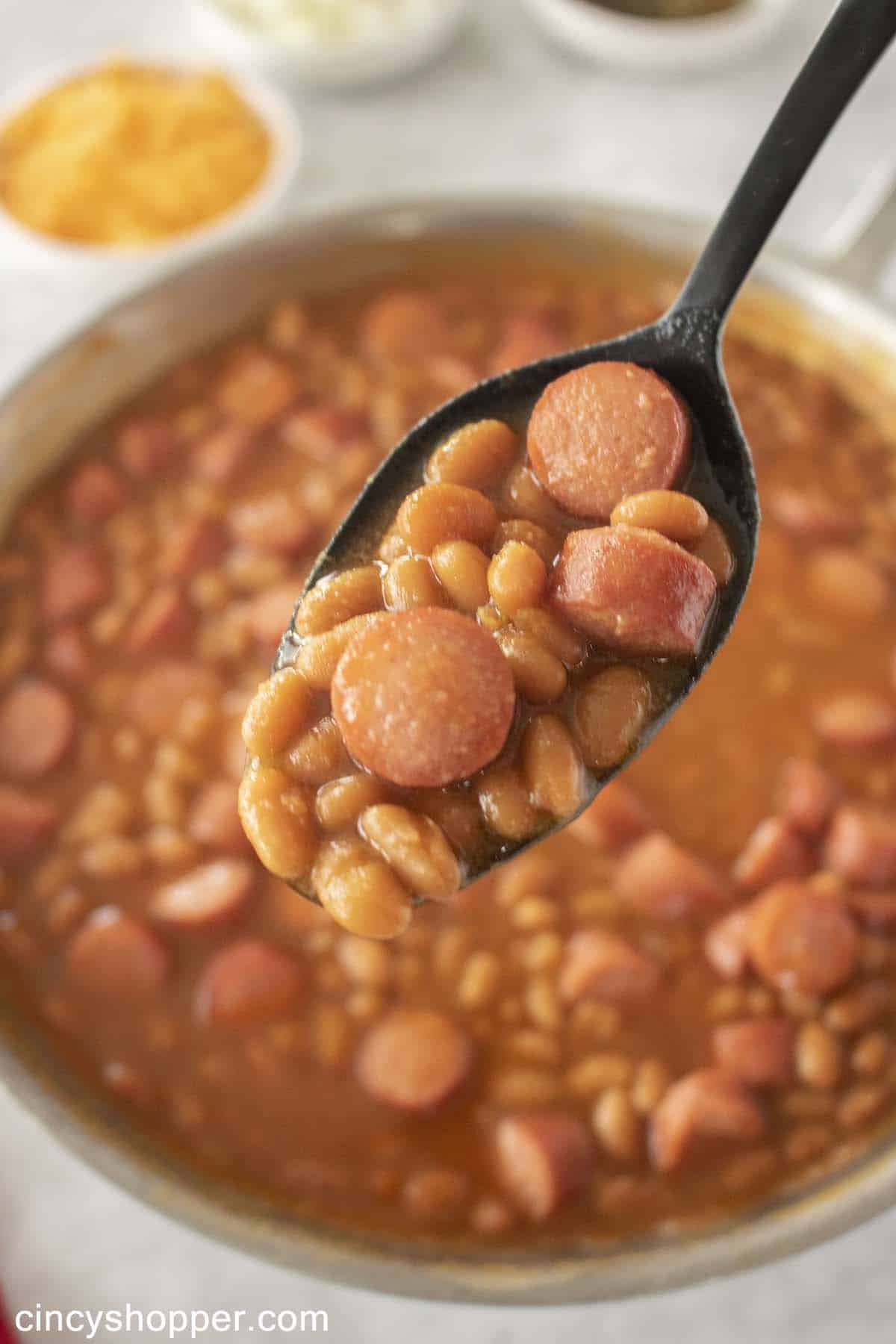 Beans with hot dogs on a spoon
