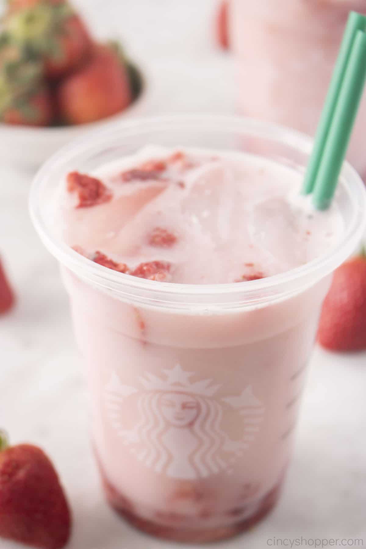 Starbucks drink with strawberries and straws.