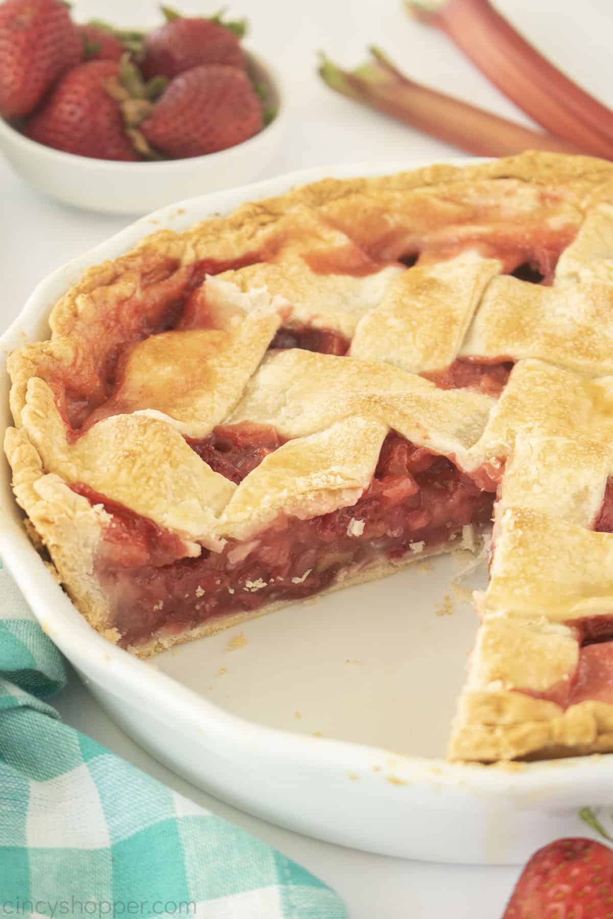 Whole Lattice topped rhubarb Pie with Strawberries one slice missing.