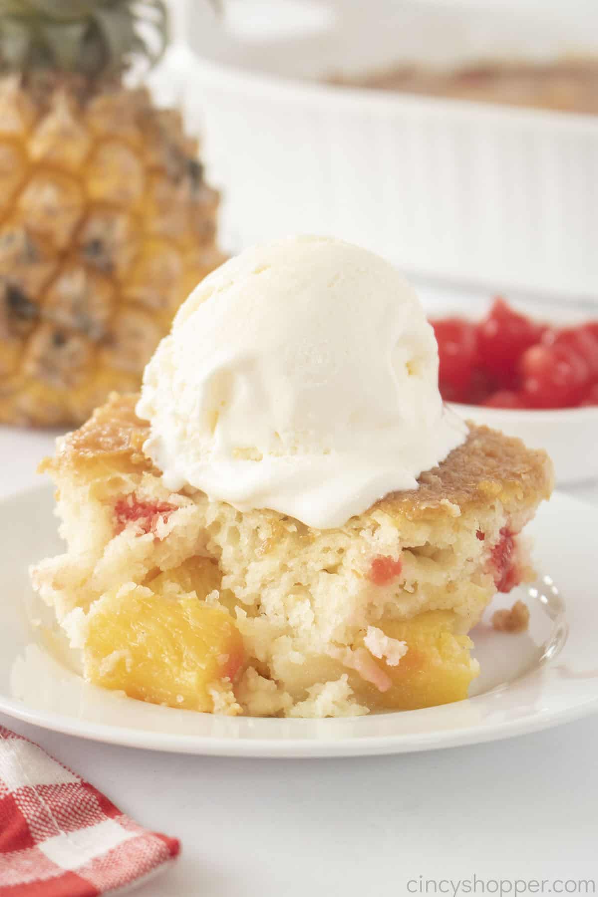 Piece of Pineapple Cobbler with ice cream on a white plate.