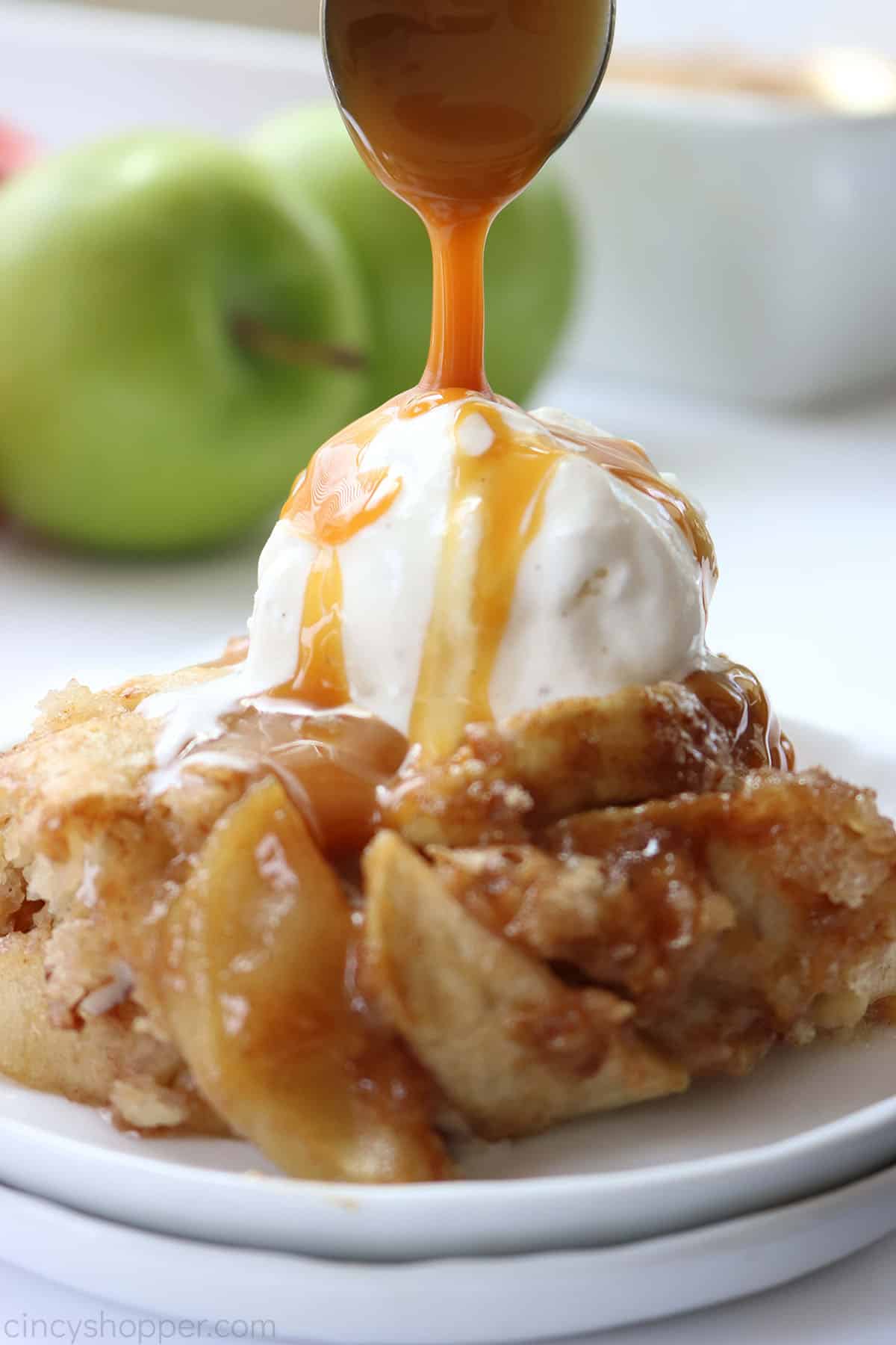 Caramel sauce drizzling over apple cobbler with ice cream.