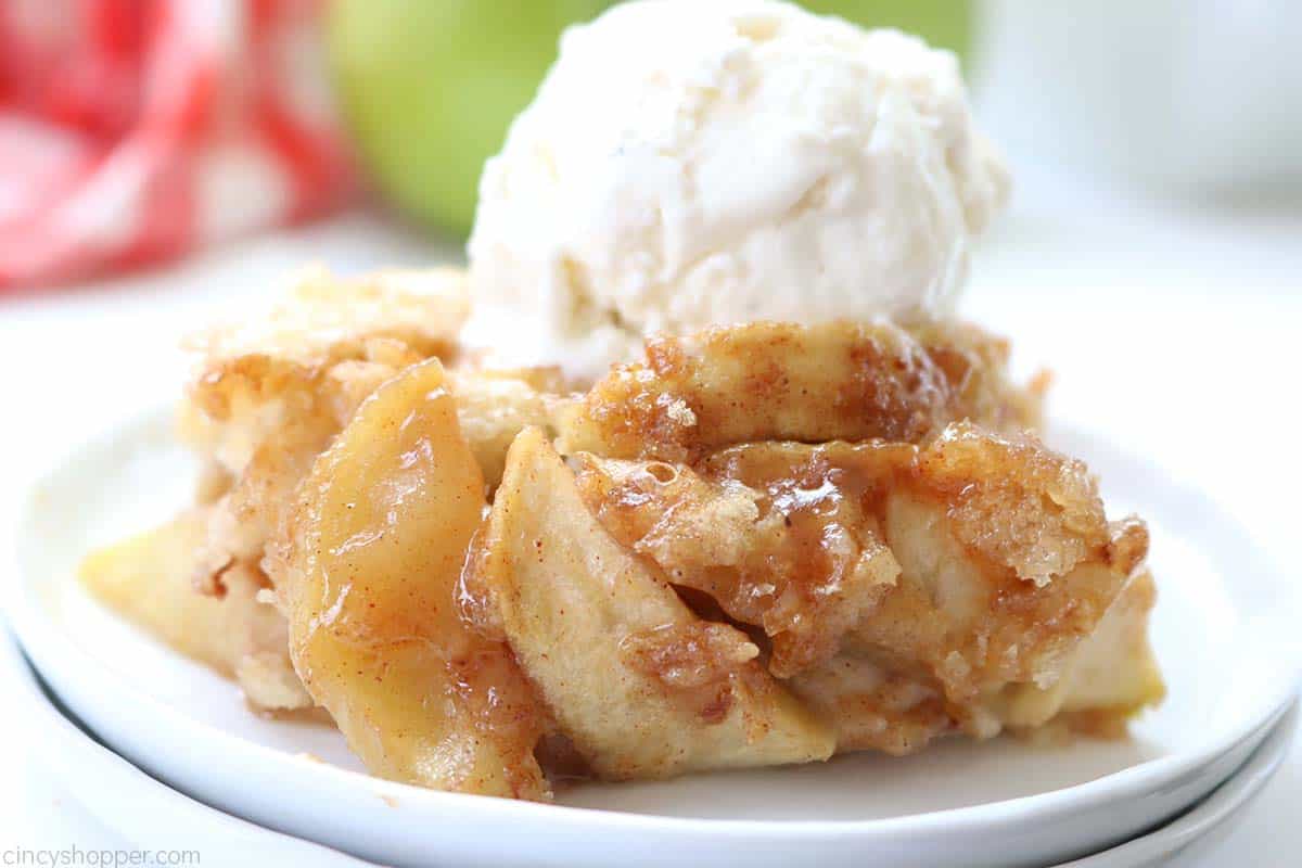 From scratch apple cobbler with ice cream on a white plate.