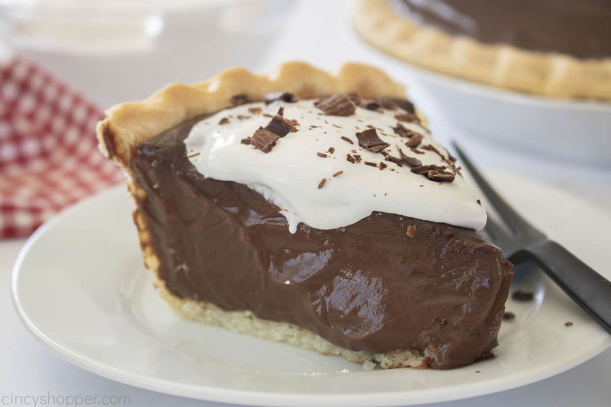 Slice of chocolate pie with whipped cream and chocolate shavings.