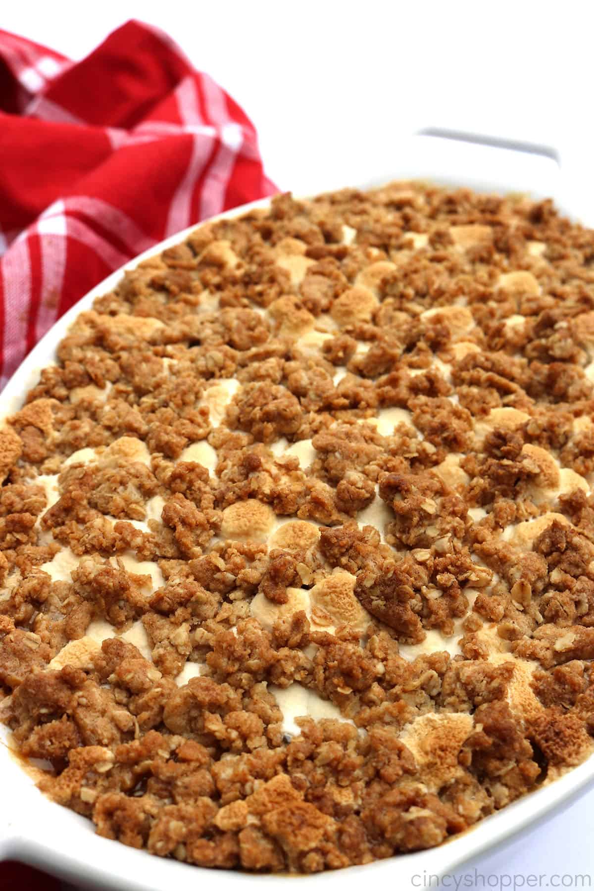 Sweet Potato Casserole with streusel and marshmallow topping in a white dish.