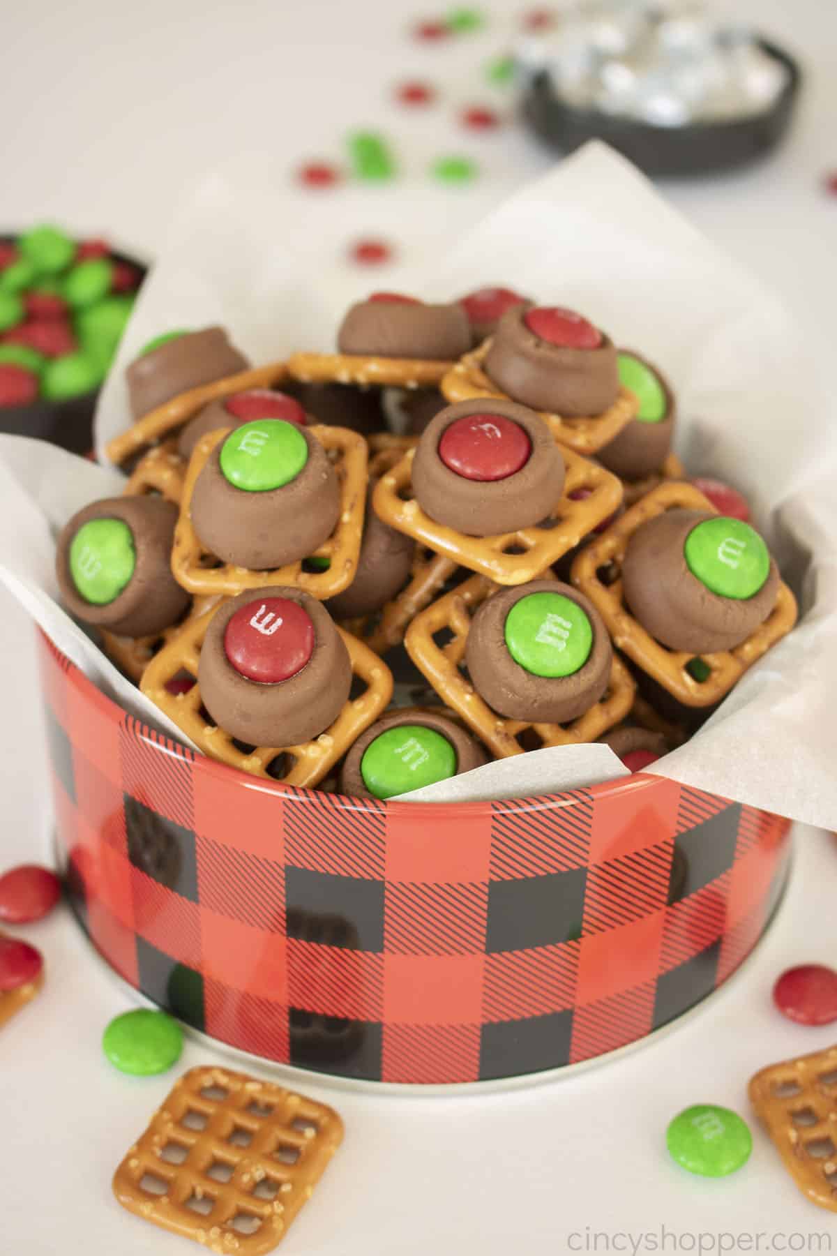 Pretzel Hershey Kiss M&M in a red and black round tin.
