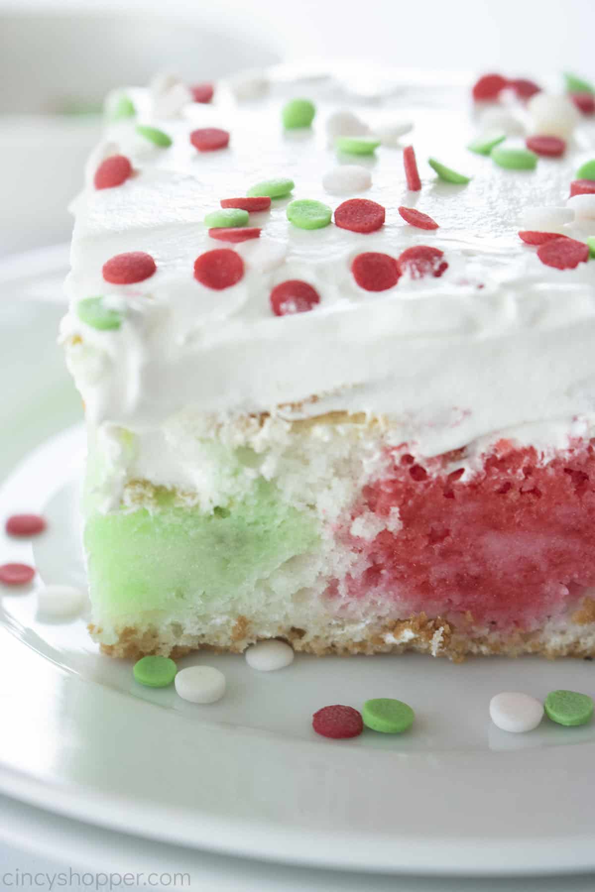 Closeup of Christmas Jello Poke Cake on a white plate.