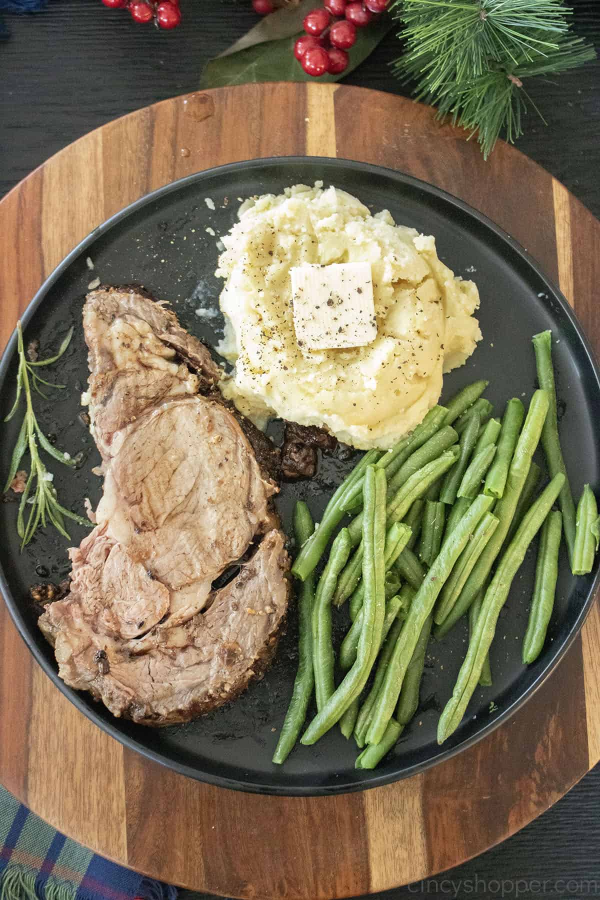 Prime Rib on a plate with mashed potatoes and green beans.