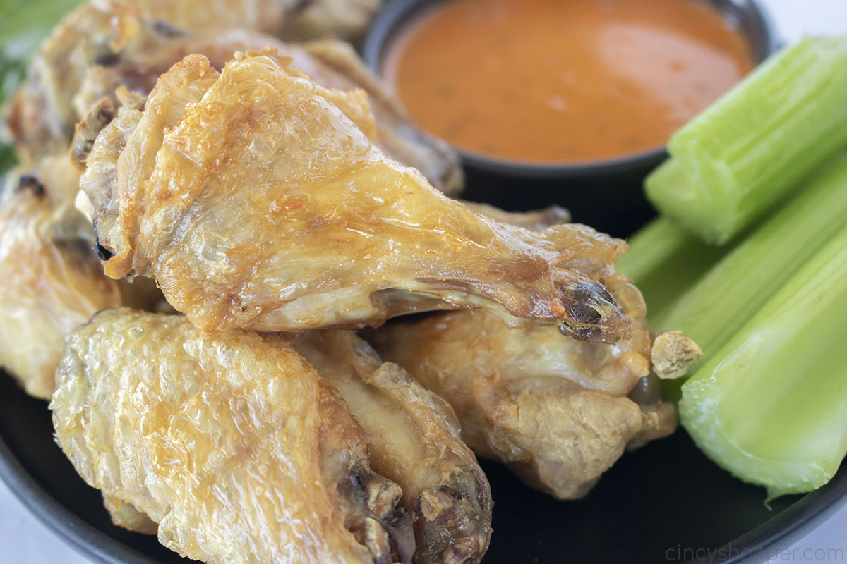 Crispy boiled chicken wings baked in the oven with buffalo sauce and celery.