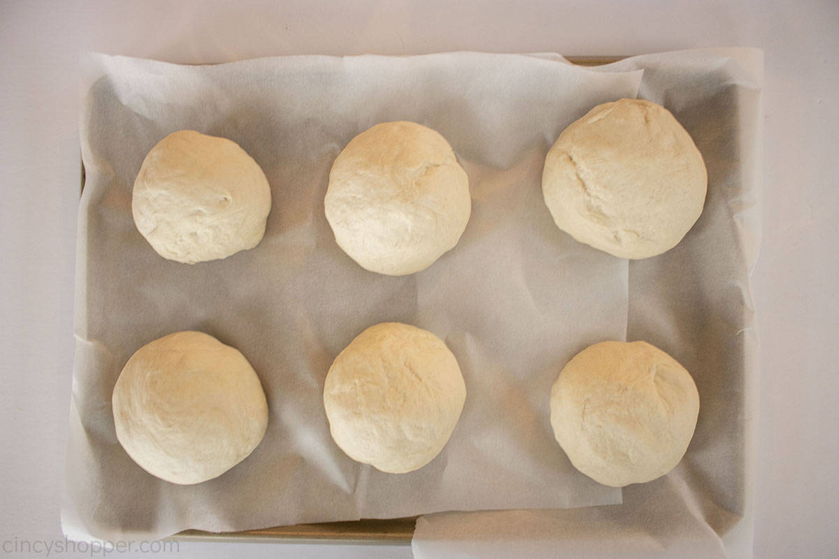 Dough balls on a parchment lined baking sheet.