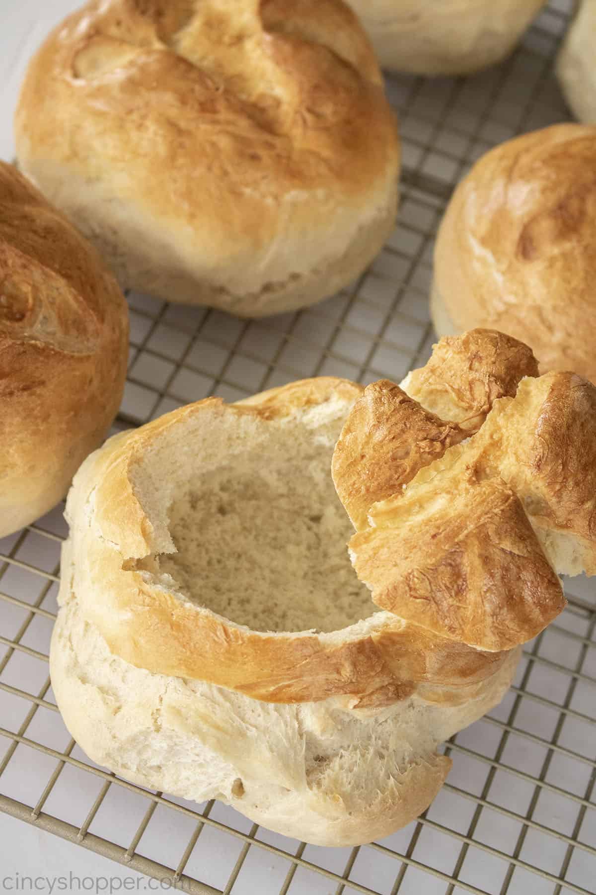 Homemade bread bowls on a wire rack.