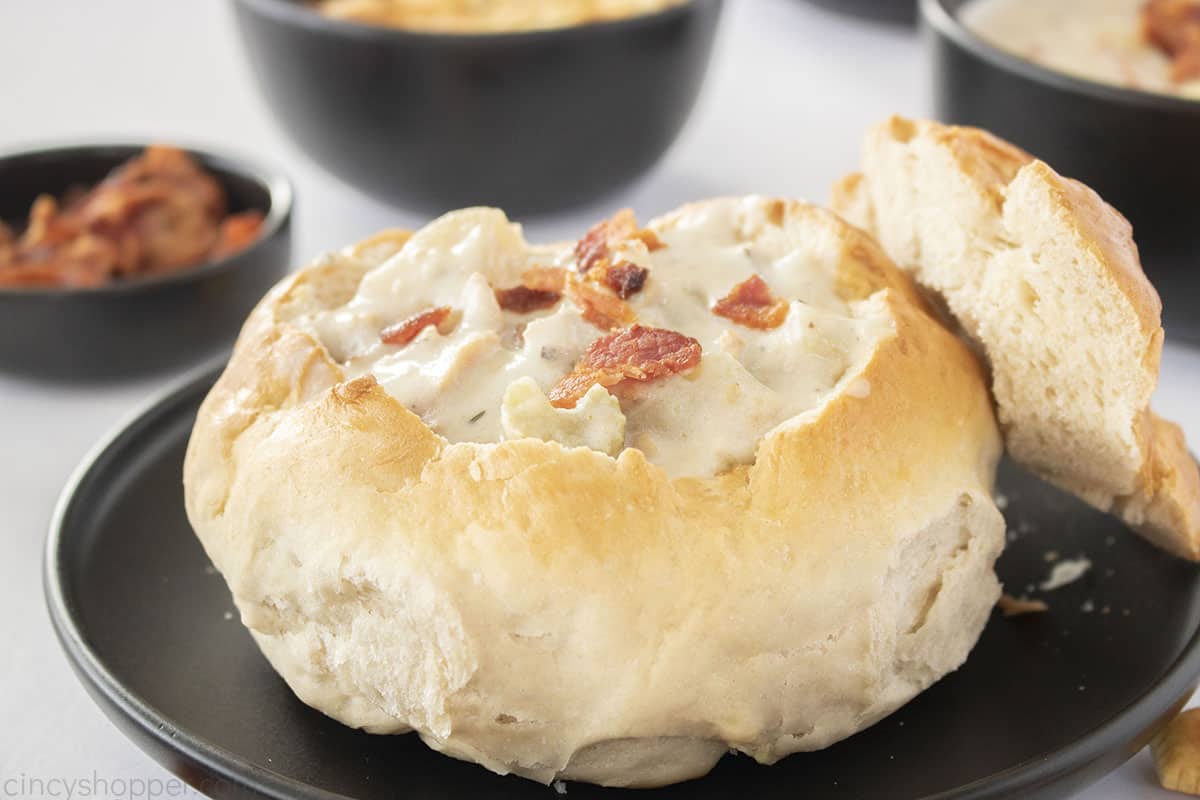 San Fransisco style Clam Chowder bread bowl on a black plate.