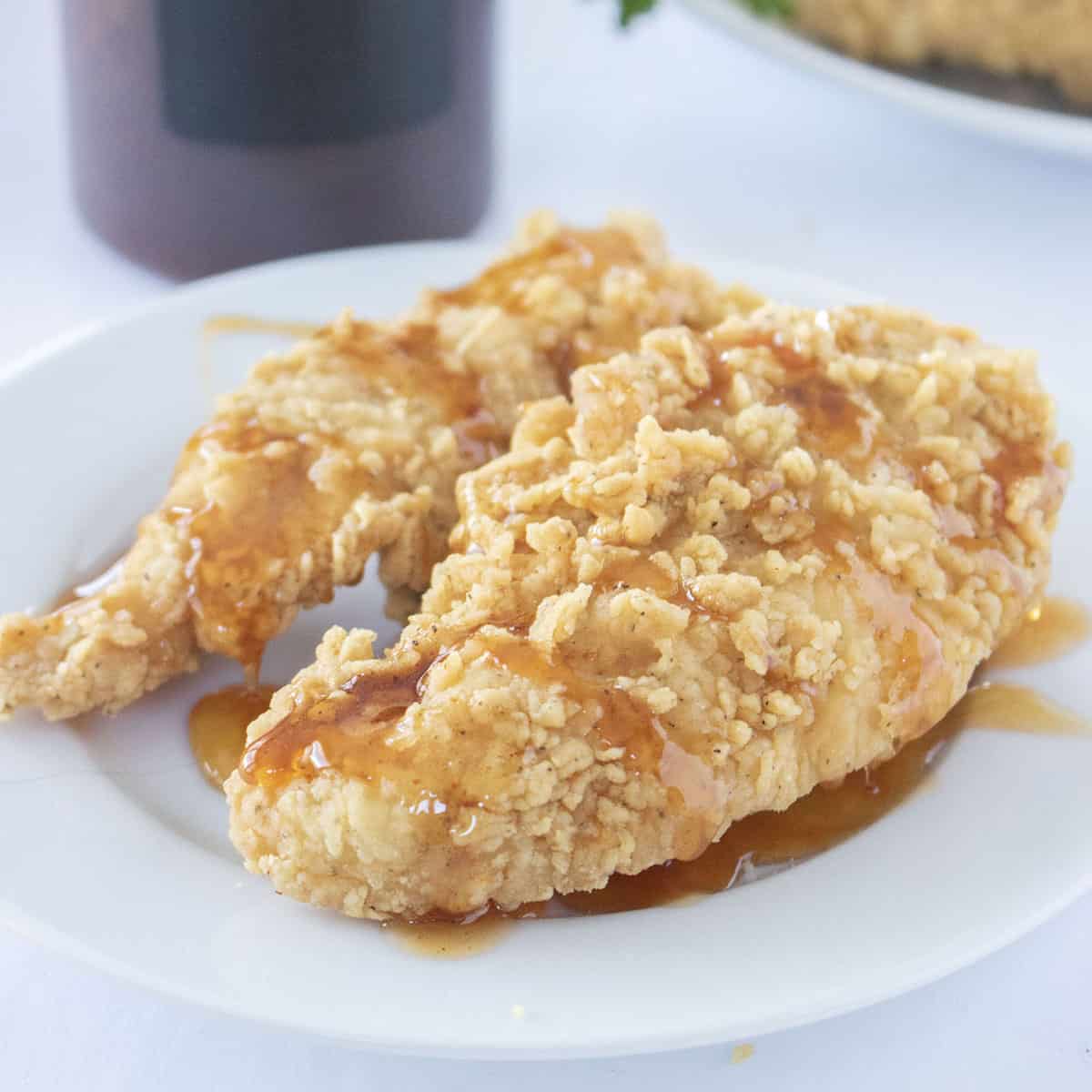 Hot Honey Sauce drizzled on the top of fried chicken tenders.