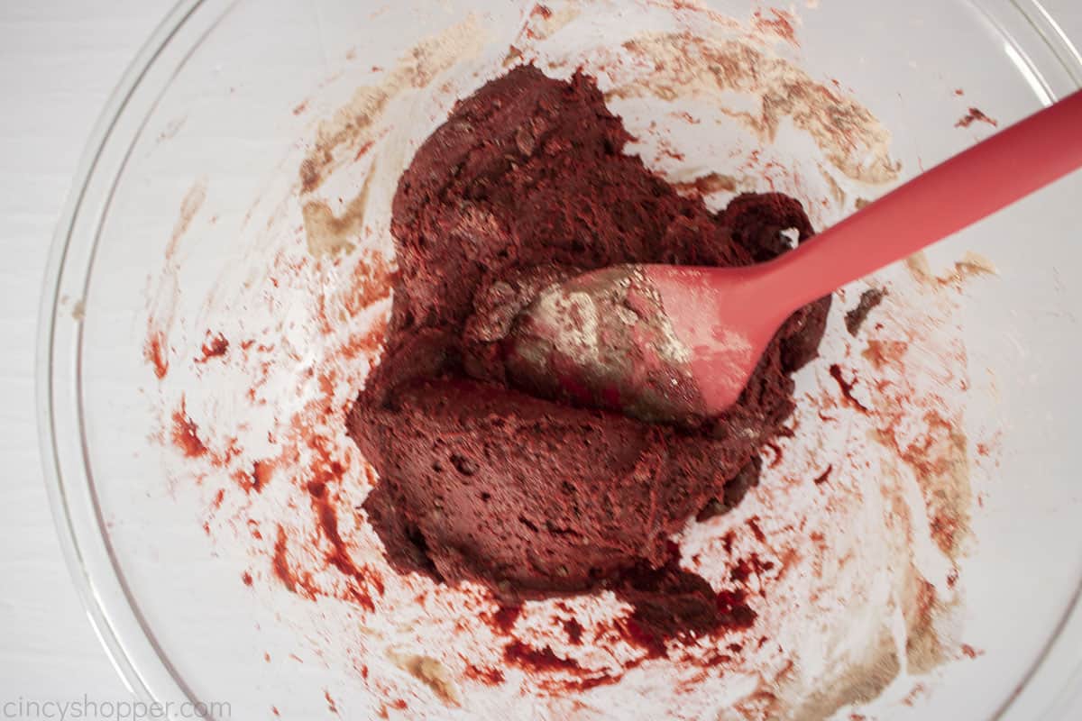 Red velvet cookie dough in a clear mixing bowl.