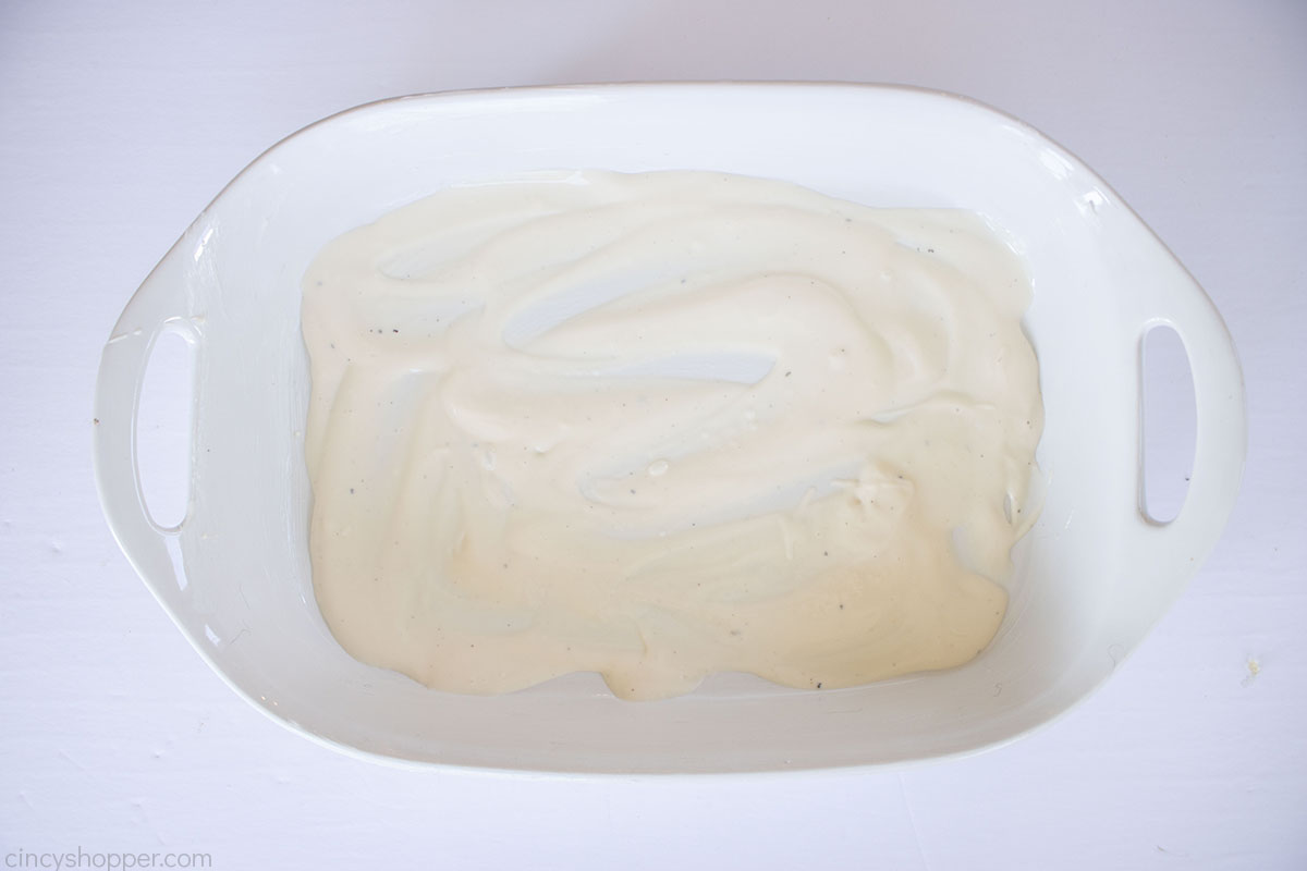 Alfredo sauce in the bottom of a greased baking dish.