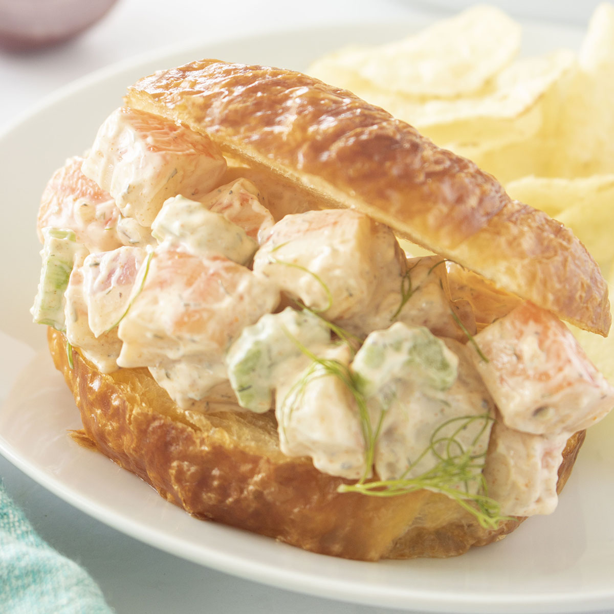 Crab Salad Sandwich on a white plate with potato chips.