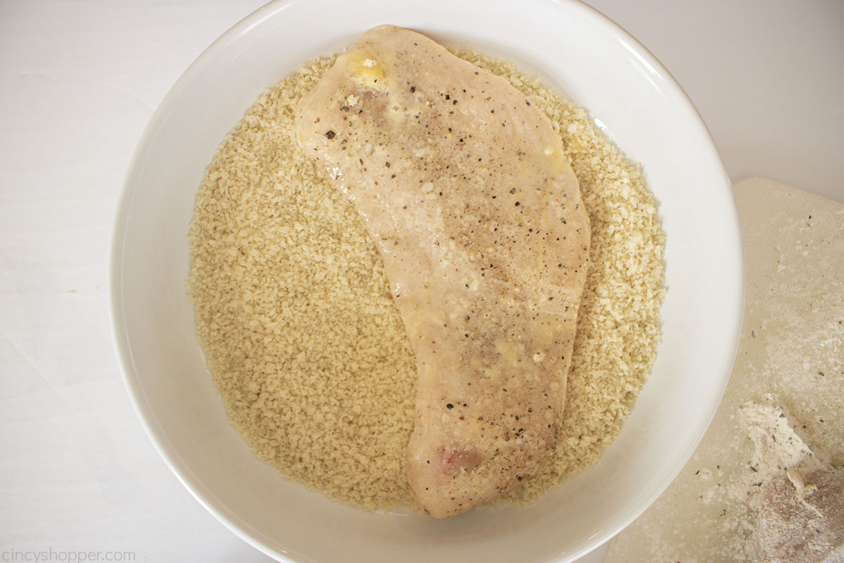 White bowl with panko crumbs and chicken.