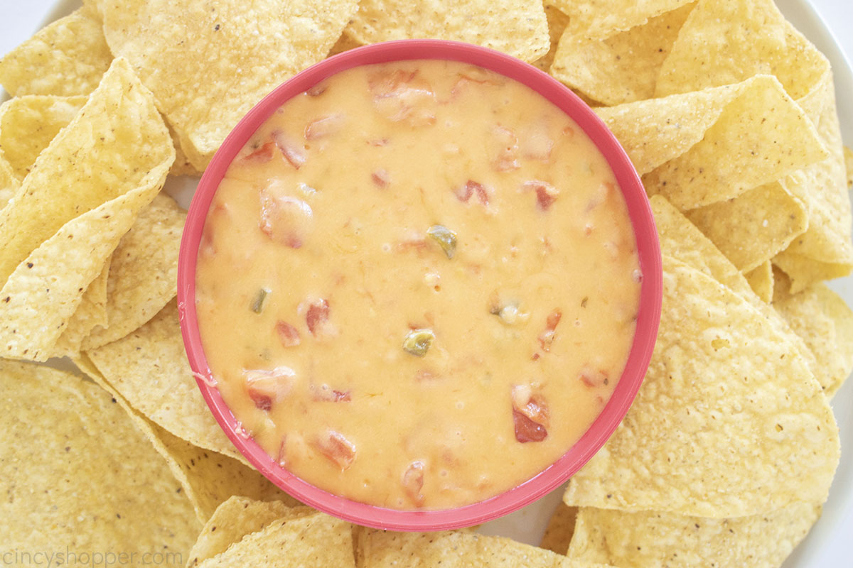 Cheesy Mexican Salsa dip in a bowl with tortilla chips on the side.