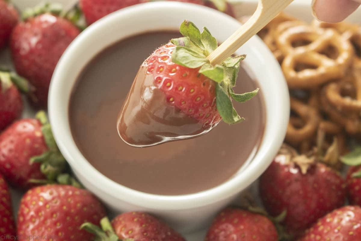 A strawberry dipped in melted chocolate sauce.