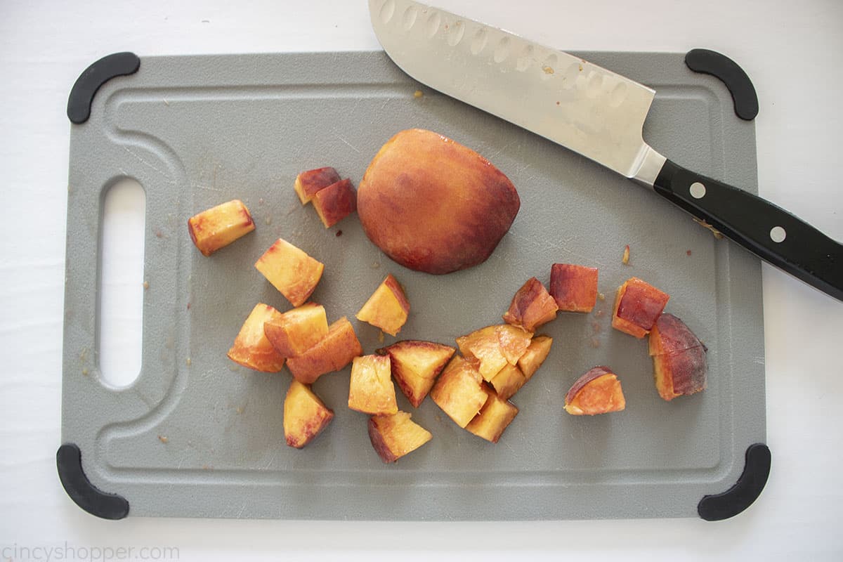 Diced fresh peaches on a cutting board.