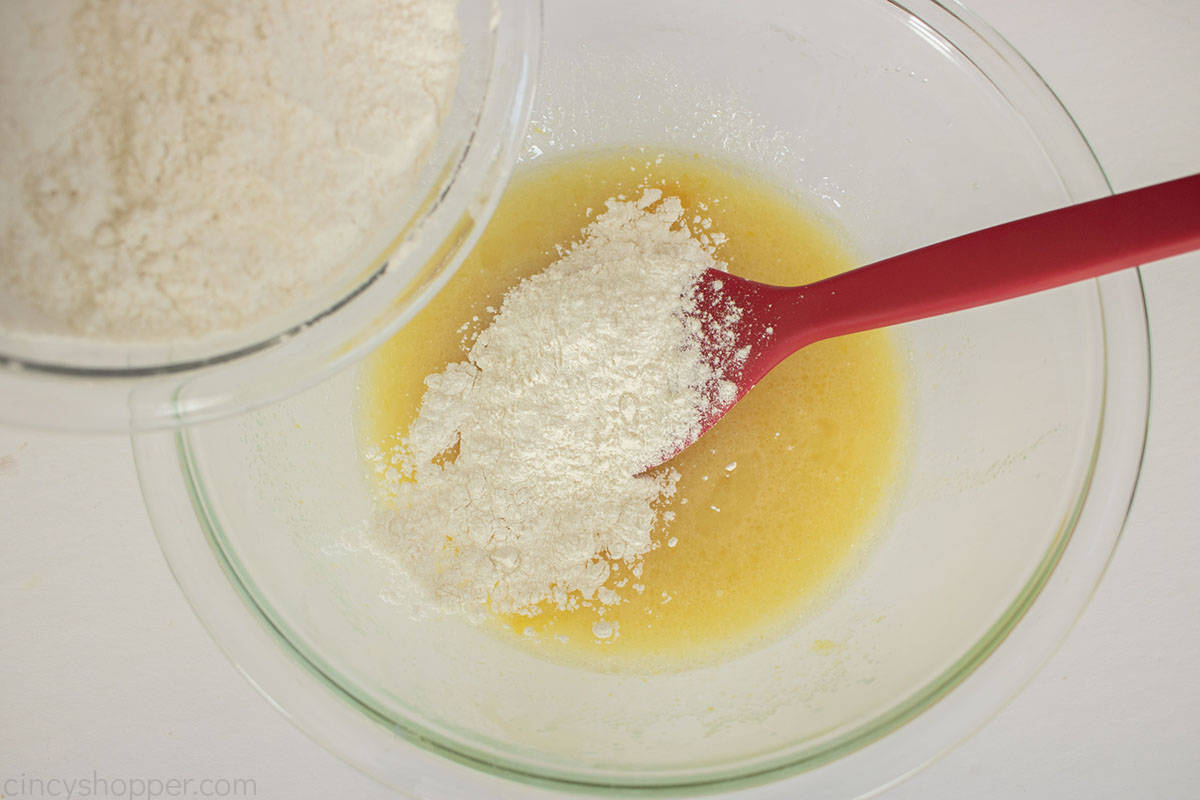 Adding the dry ingredients to wet ingredients for dessert bread.