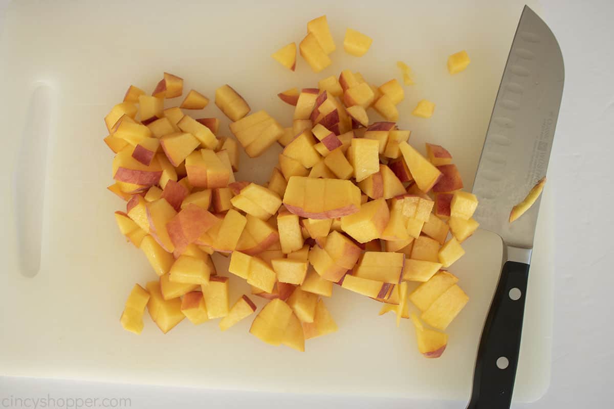 Fresh diced peaches on a cutting board.