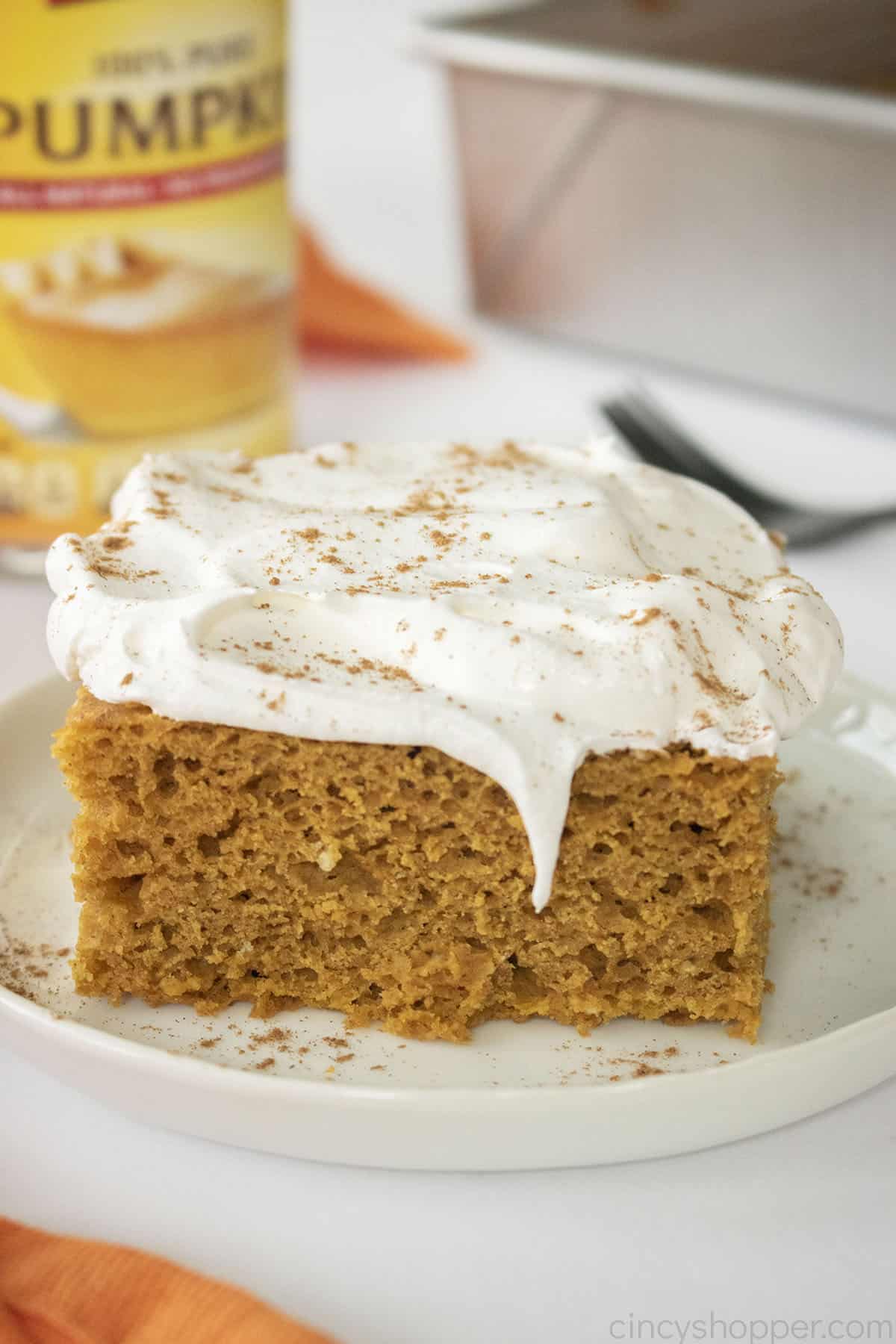 3 Ingredient Pumpkin Spice Cake with whipped cream on a white plate.