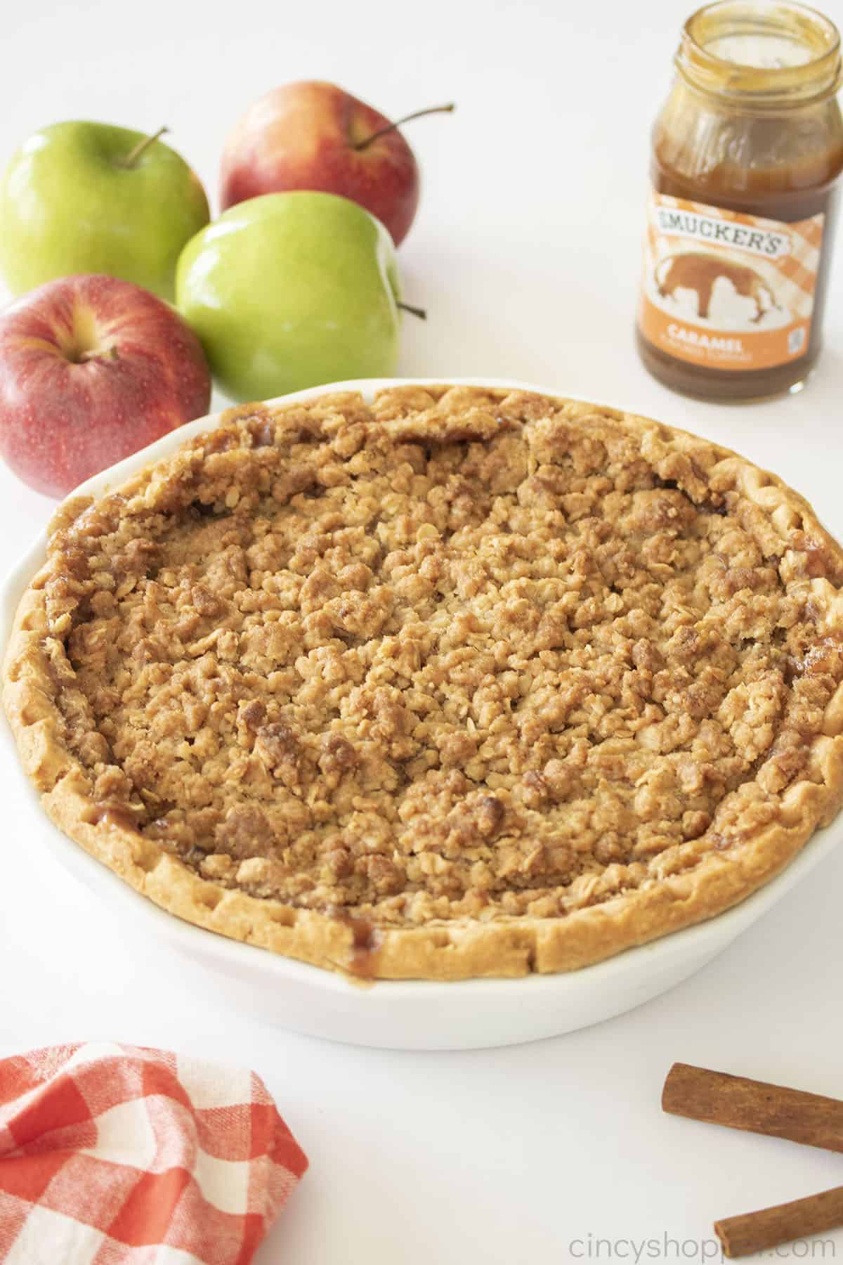 Full Apple Pie Cheesecake in a white pie plate.