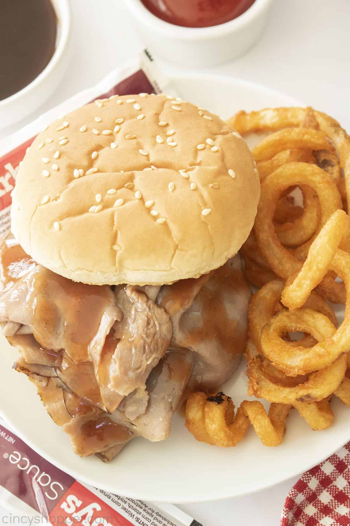 CopyCat Arby's Roast Beef Sandwich on a white plate with curly fries.