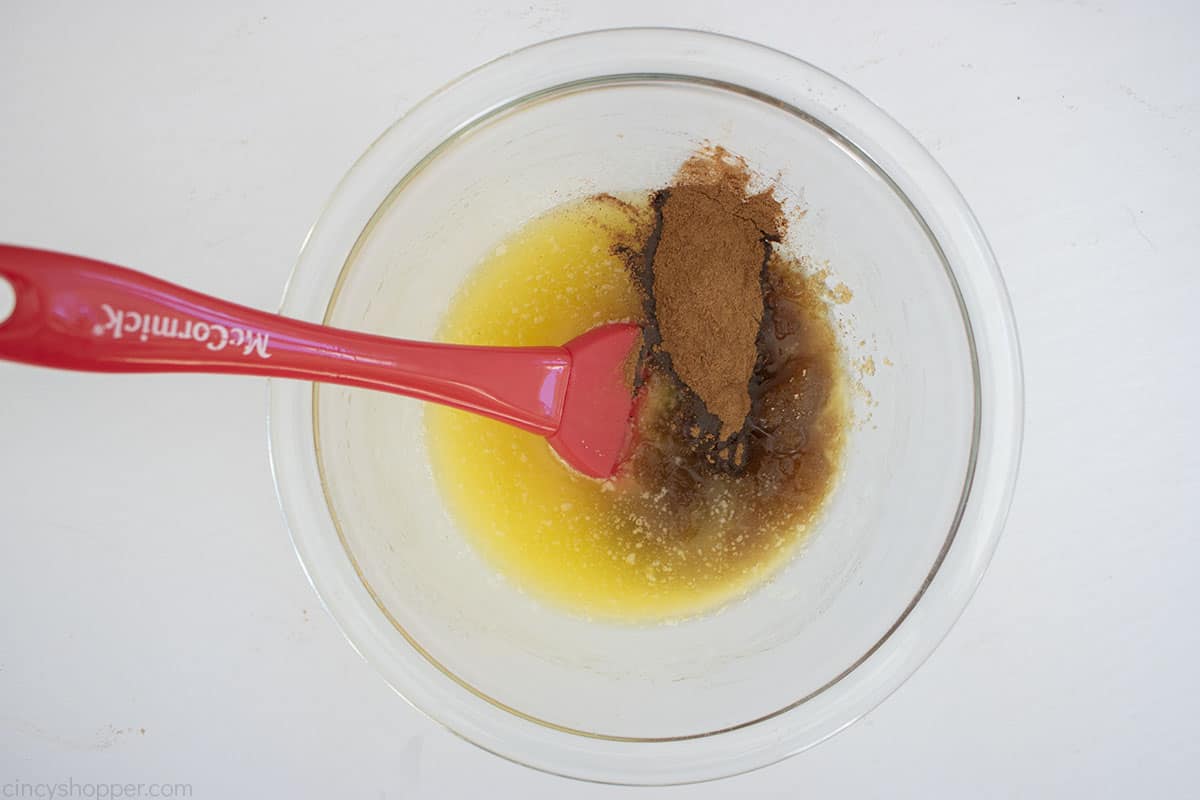 Melted butter, cinnamon and sugar in a clear mixing bowl.