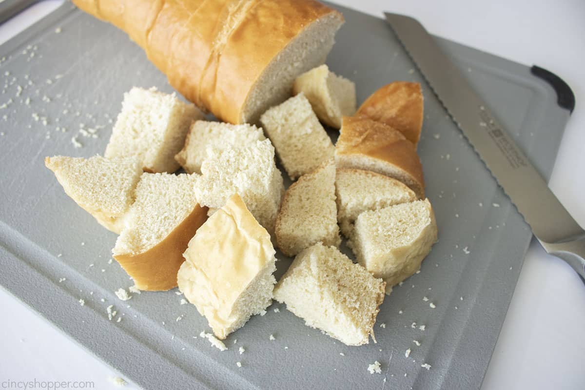 Cubed french bread on a cutting board.