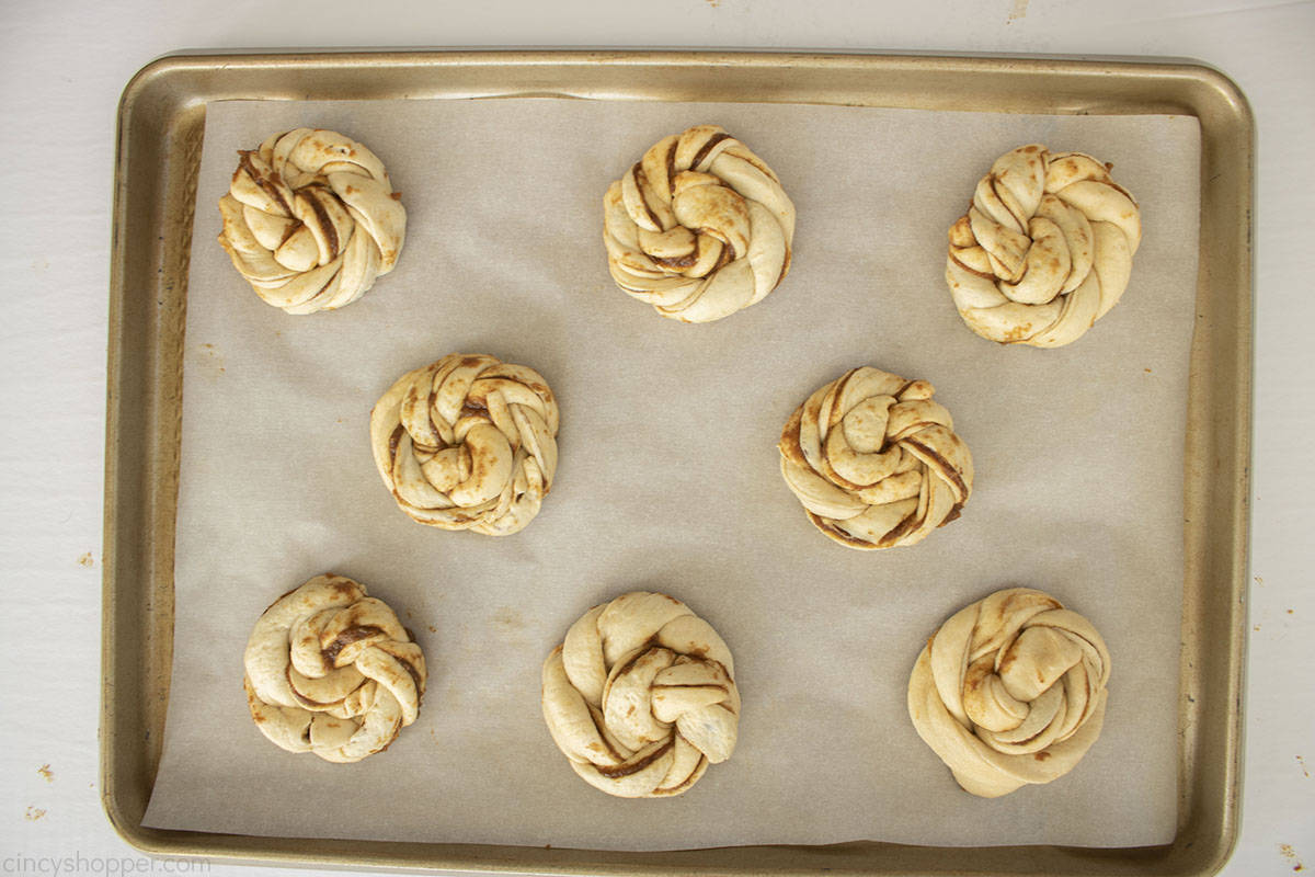 Easy Pumpkin Cinnamon Roll Crescents on a pan with parchment paper.