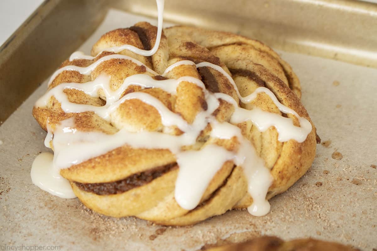 Icing drizzled on the top of baked Easy Pumpkin Cinnamon Rolls.