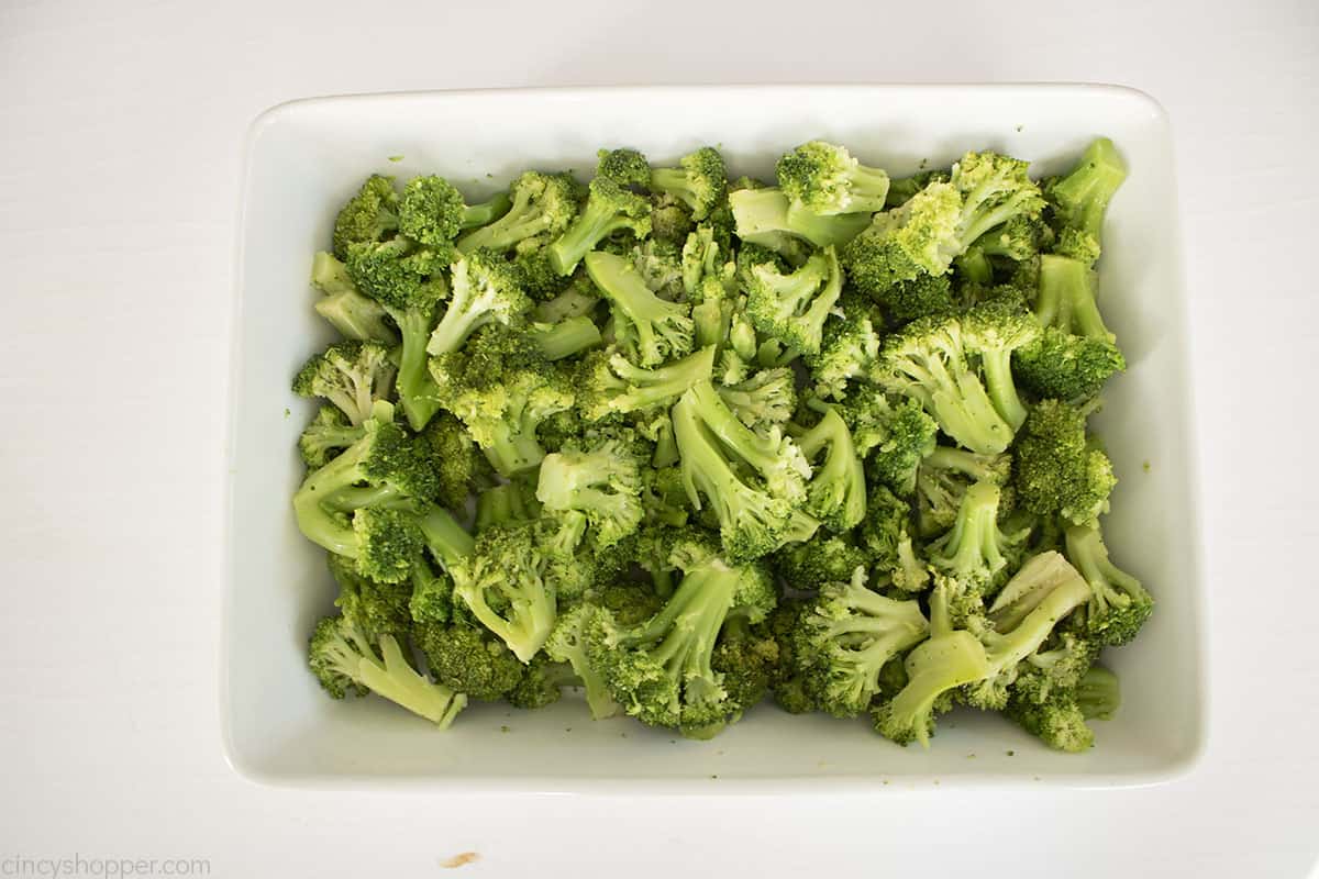 Cooked broccoli in a white casserole dish.