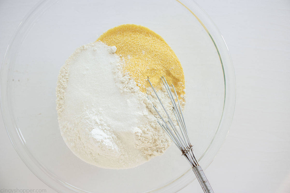 From scratch cornbread ingredients in a clear bow lwith a whisk.