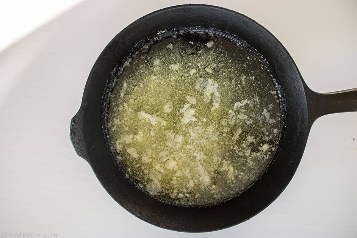 Butter melted in a black cast iron pan.