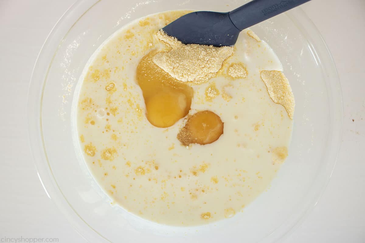 Wet cornbread ingredients added to dry ingredient bowl.