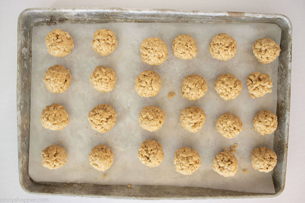 Peanut butter Rice Krispy balls on a baking sheet with parchment paper.