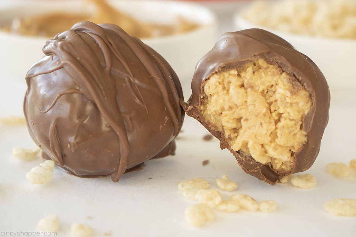 Two Rice Krispie Chocolate balls, one with a bite.