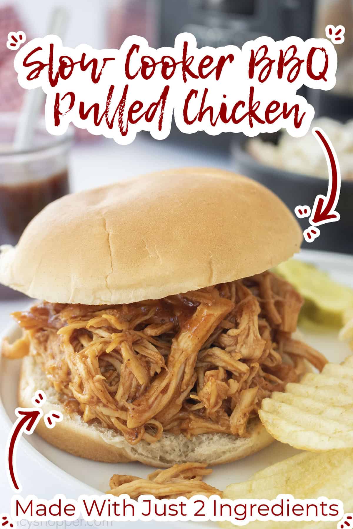 Slow Cooker BBQ Chicken on a roll with chips and ppickles.