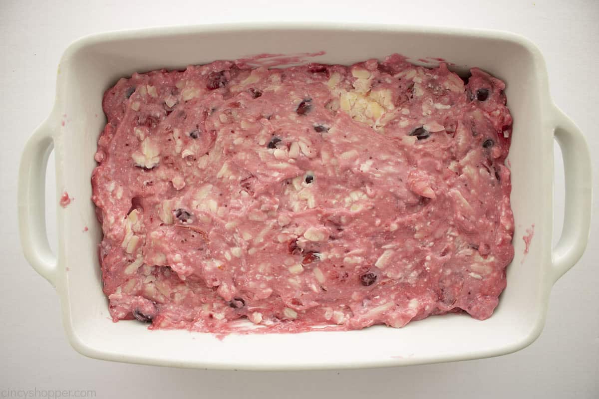 Cranberry cream cheese mixture added to small white baking dish.
