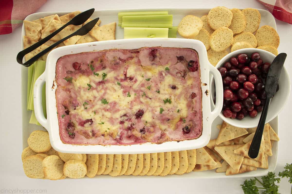 Appetizer platter with baked cranberry dip, crackers, veggies and fresh cranberries.
